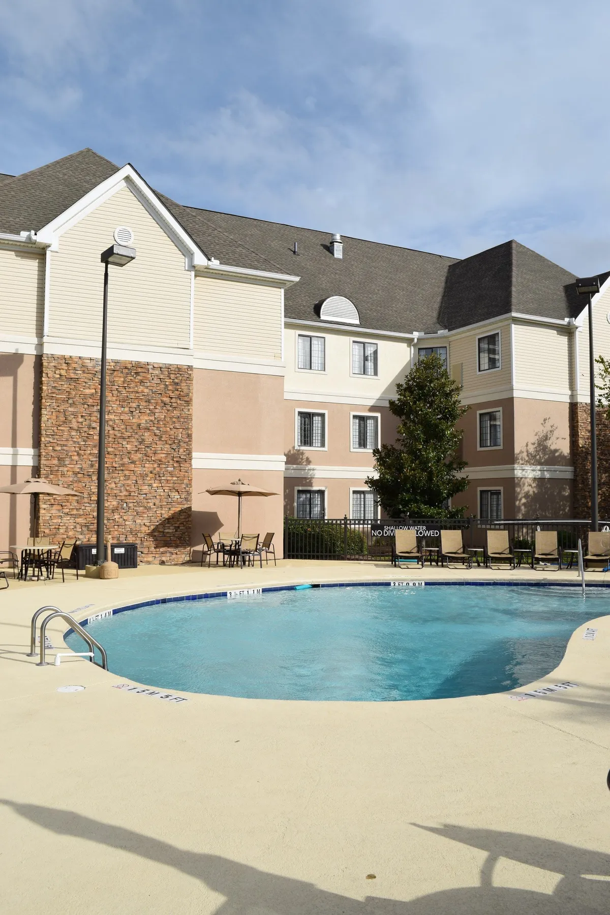 This image captures the inviting outdoor swimming pool area, with comfortable seating and the building’s facade in the background. The pool glistens under the light, suggesting relaxation and family fun, and the space is perfect for gatherings or unwinding after a day of exploring attractions.